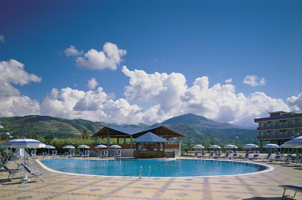 une grande piscine avec chaises et parasols dans l'établissement Hotel San Gaetano, à Grisolia