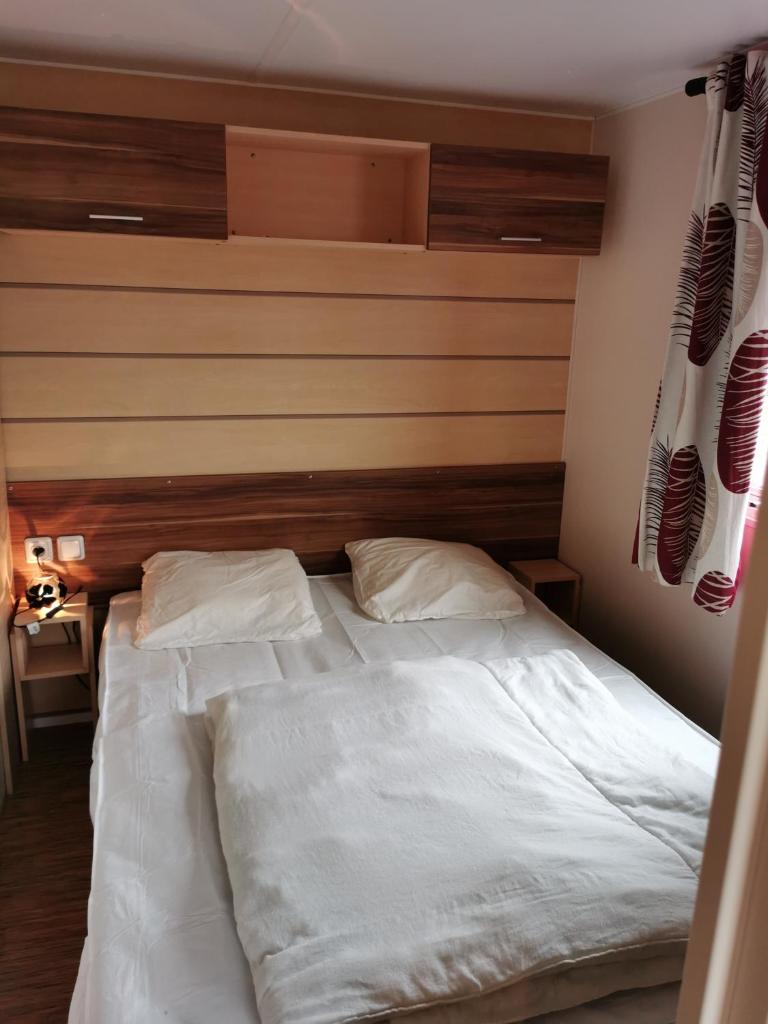 - un lit avec 2 oreillers blancs dans une chambre dans l'établissement Assist' Mobil Home 276 - Mobil home 3 chambres au calme, à Onzain