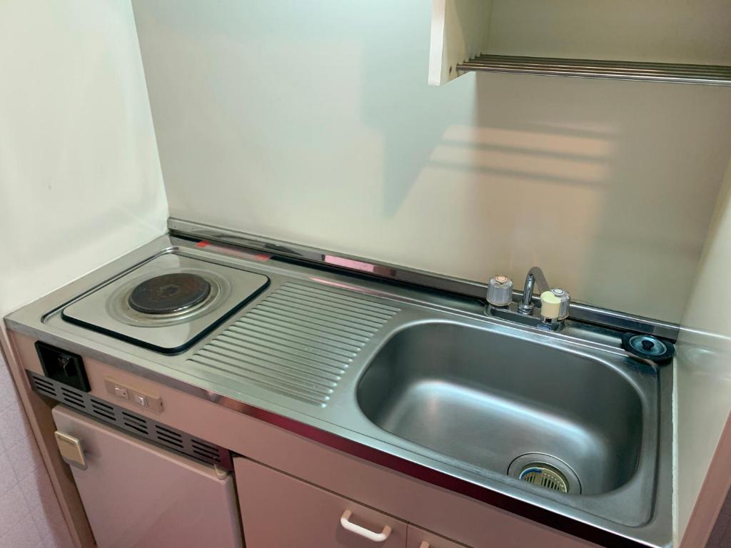 une petite cuisine avec un évier et une cuisinière dans l'établissement Star Hotel Akakura, à Myōkō