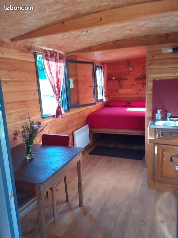 - une chambre avec un lit et une table dans une cabine dans l'établissement La Roulotte de la Clef des Champs, à Buzancy