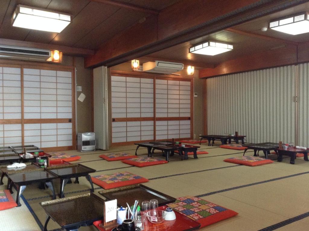 Cette chambre dispose de tables et de tapis au sol. dans l'établissement Chitosekan, à Nozawa Onsen