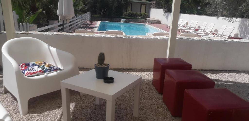 une terrasse avec des chaises, une table et une piscine dans l'établissement "San Placido Green House" Villa con Piscina, à Castel di Iudica