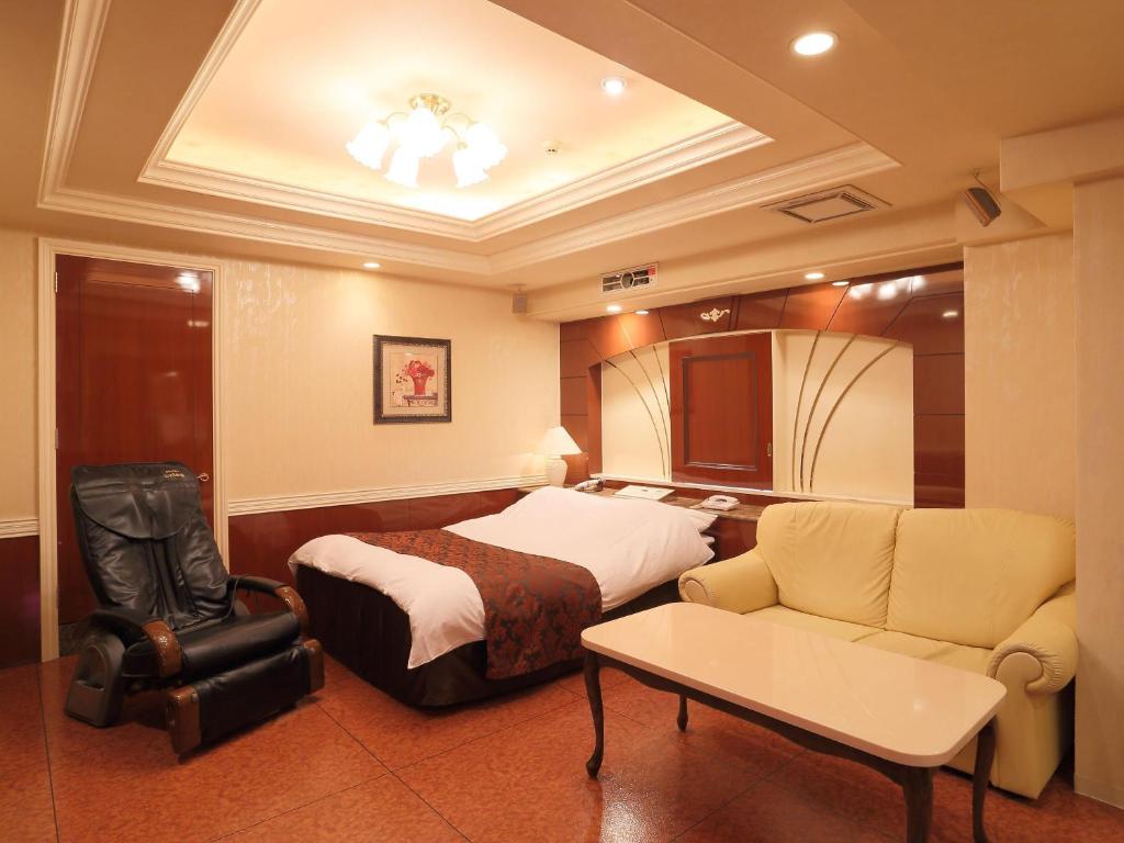 une chambre d'hôtel avec un lit et un canapé dans l'établissement Hotel Fine Garden Kuwana, à Kawagoe 16 autres photos