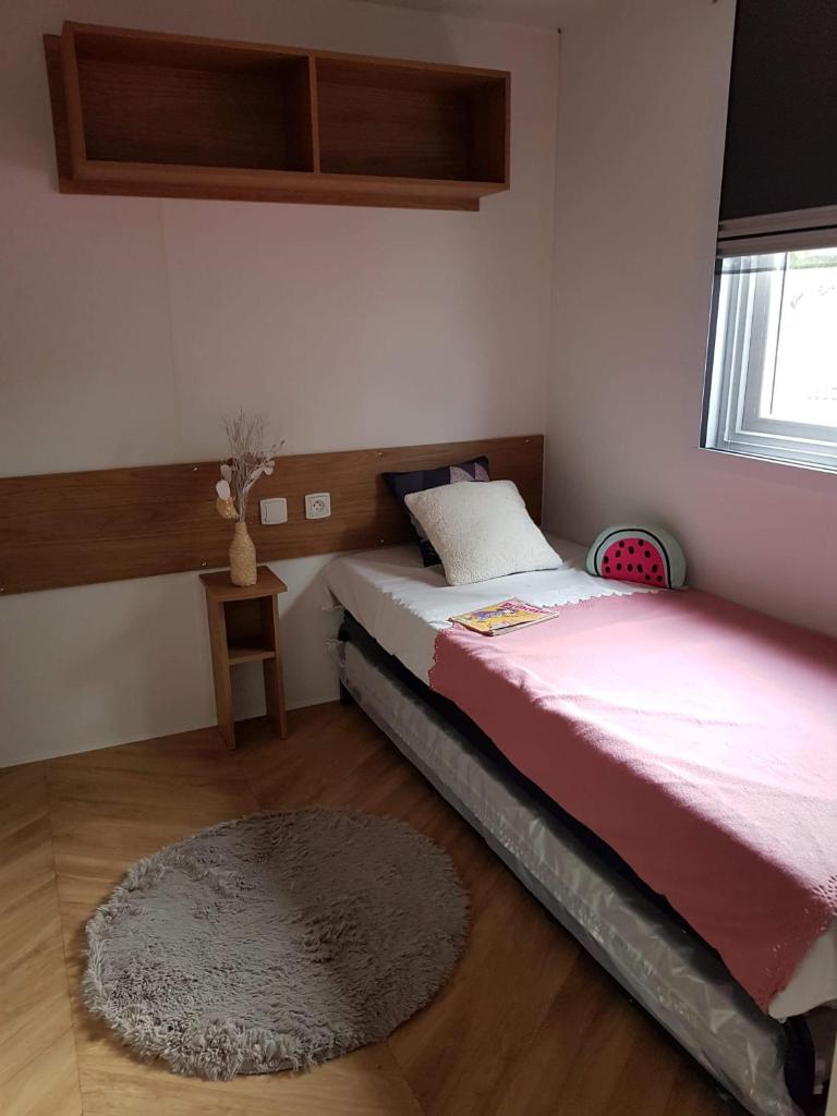 - une petite chambre avec un lit et un tapis dans l'établissement Mobilhome la carabasse, à Vias 5 autres photos