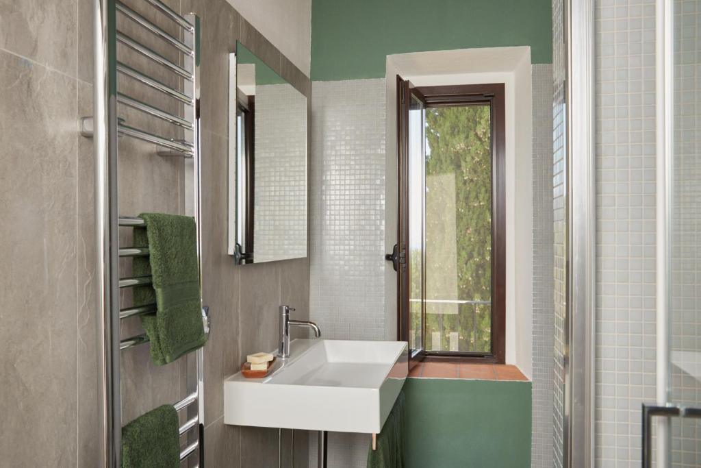 une salle de bain avec un lavabo blanc et une fenêtre dans l'établissement Grandono Agriturismo in Maremma, à Scansano 7 autres photos