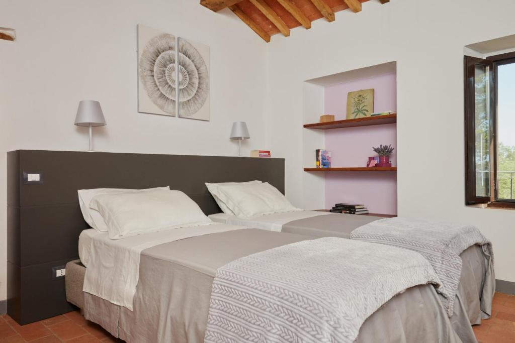une chambre avec un grand lit avec deux oreillers dans l'établissement Grandono Agriturismo in Maremma, à Scansano