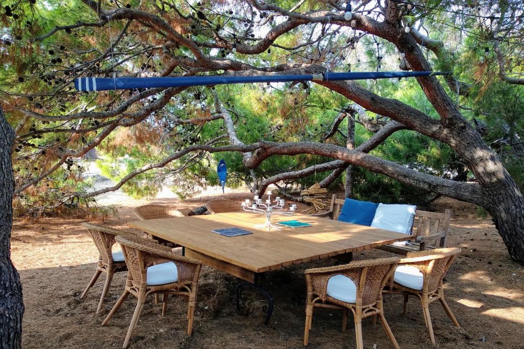 une table et des chaises en bois sous un arbre dans l'établissement Trullammare, à Monopoli