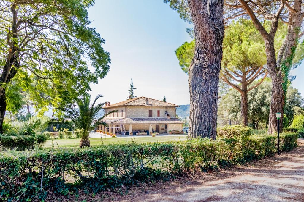 une maison au milieu d'un parc avec des arbres dans l'établissement Gorgeous 2-storey villa with a large private pool, à Todi