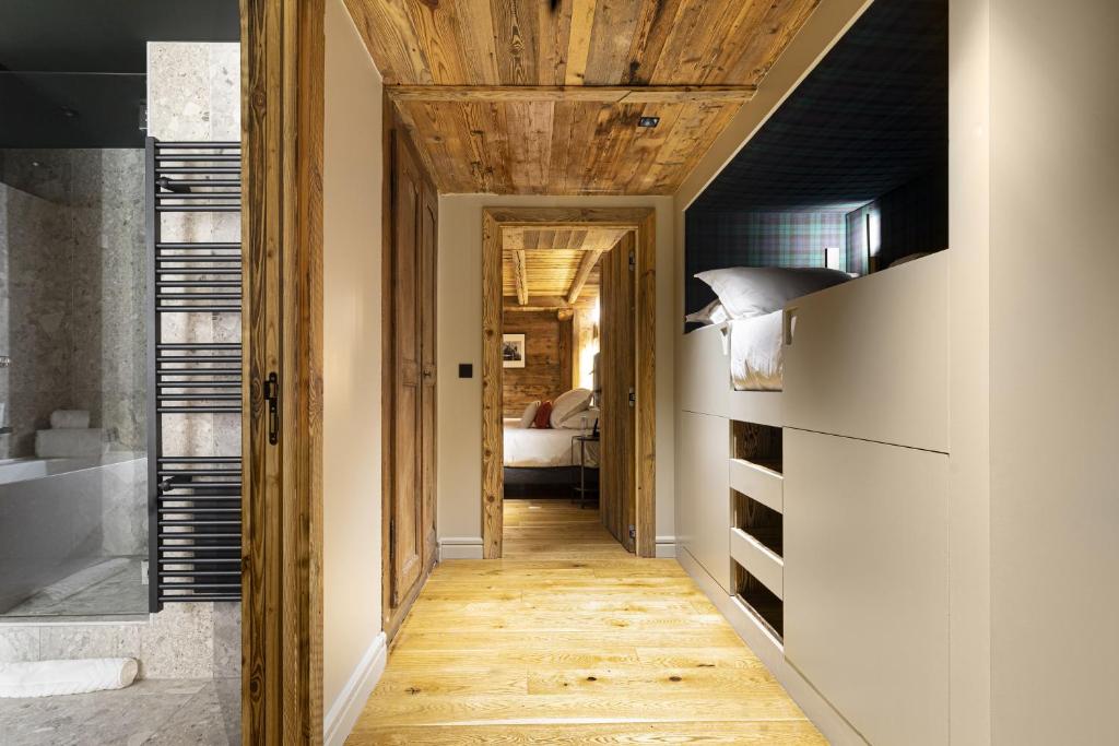 - un couloir menant à une chambre dotée d'un plafond en bois dans l'établissement Hotel Le Chabichou, à Courchevel