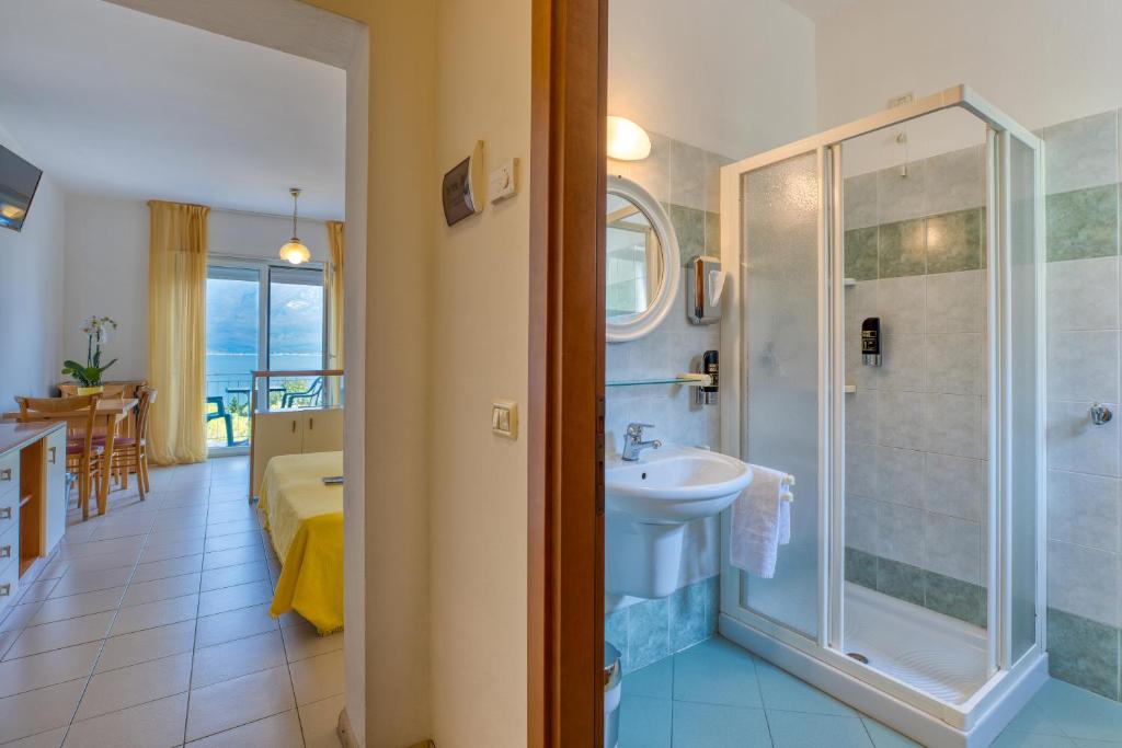 une salle de bain avec douche, lavabo et toilettes dans l'établissement Hotel Casa Piantoni, à Limone sul Garda