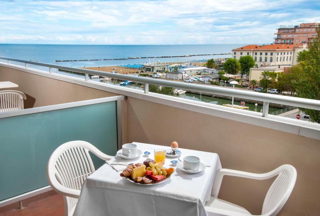 une table avec un bol de fruits sur un balcon dans l'établissement Hotel Cormoran, à Cattolica