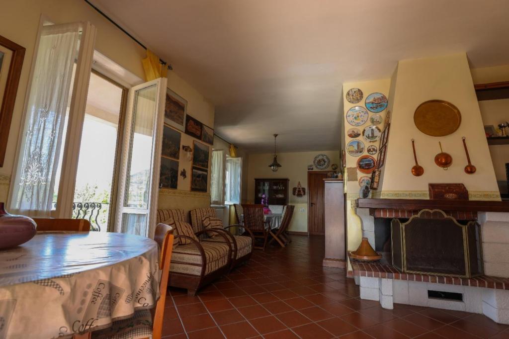 un salon avec une table et une cheminée dans l'établissement Villa Santulli with private pool, à Laureana Cilento
