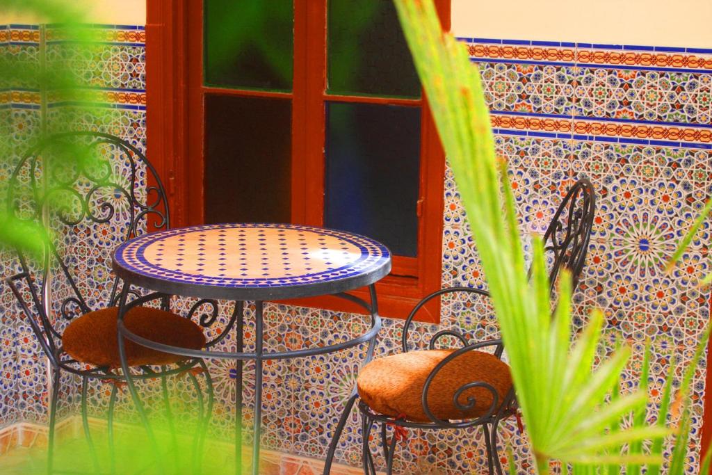 d'une terrasse avec 2 chaises, une table et une fenêtre. dans l'établissement Riad Dar Al Fassia, à Oujda