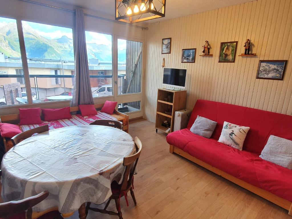 un salon avec un canapé rouge et une table dans l'établissement Studio Queyrelet 1 pied des pistes avec balcon & vue 2-4 personnes, à Orcières