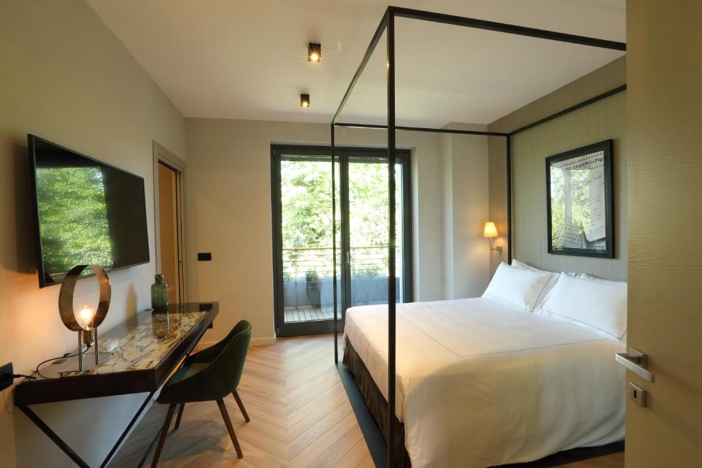 Cette chambre comprend un lit et un bureau avec un miroir. dans l'établissement Villa Carla @ Barolo, à Barolo 46 autres photos