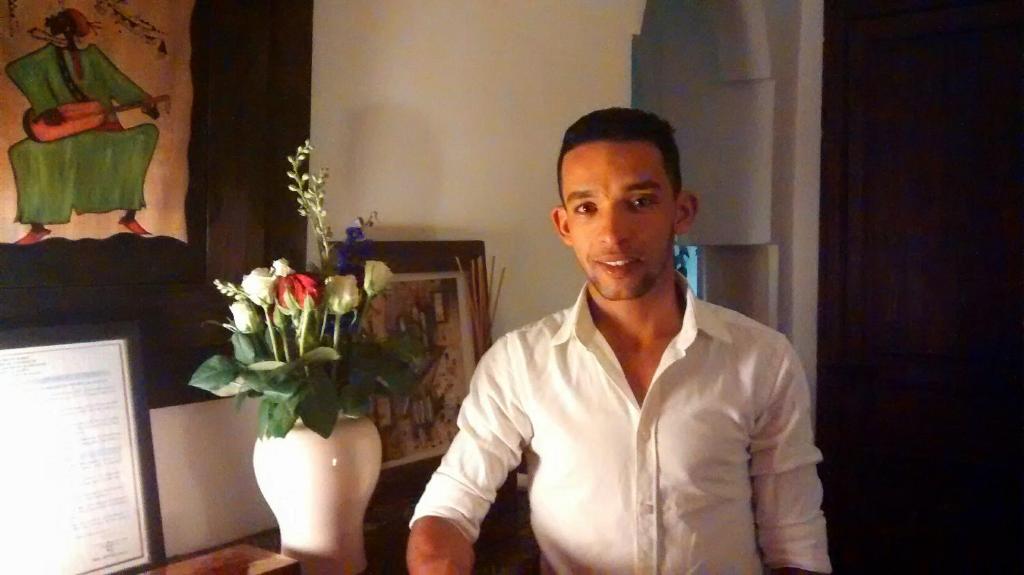 un homme assis sur un bureau avec un vase de fleurs dans l'établissement Riad Dar Zaman, à Marrakech 37 autres photos