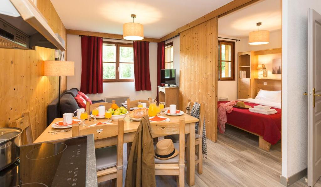 une cuisine et un salon avec une table dans une pièce dans l'établissement Résidence Odalys L'Orée des Pistes, à Saint-Sorlin-dʼArves