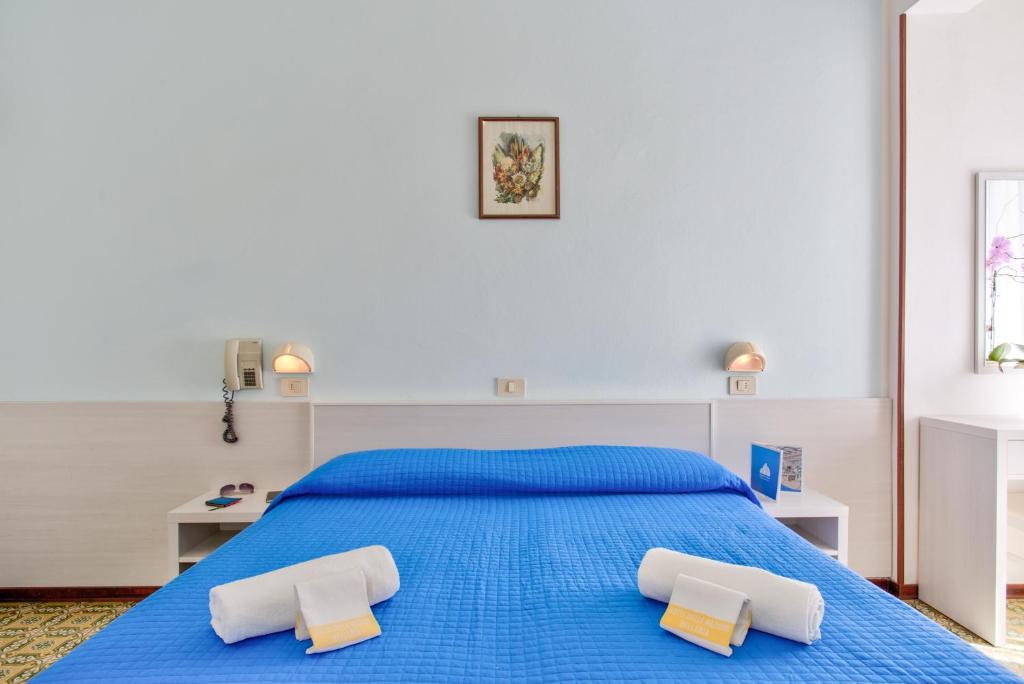- une chambre avec un lit bleu et 2 oreillers blancs dans l'établissement Hotel Delle Nazioni - Valentini Family Village, à Bellaria-Igea Marina 22 autres photos