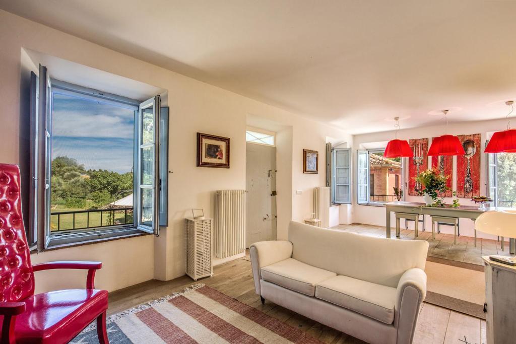 - un salon avec un canapé, une chaise et une table dans l'établissement Villa Benedetta - Homelike Villas, à Osimo