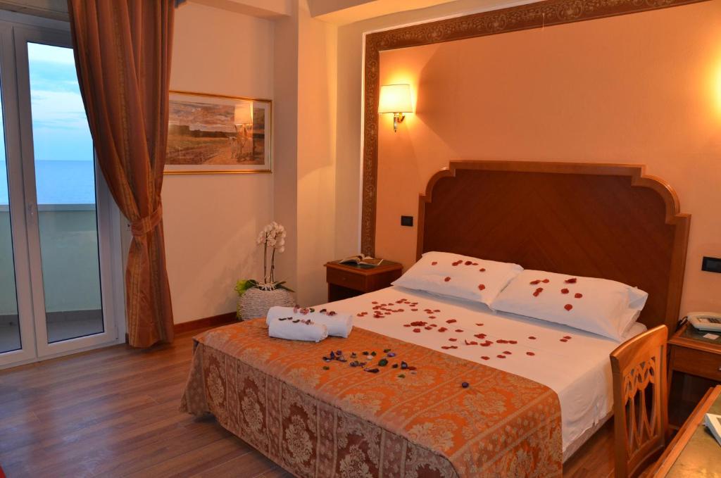 une chambre avec un lit avec des fleurs dessus dans l'établissement Grand Hotel Montesilvano, à Montesilvano