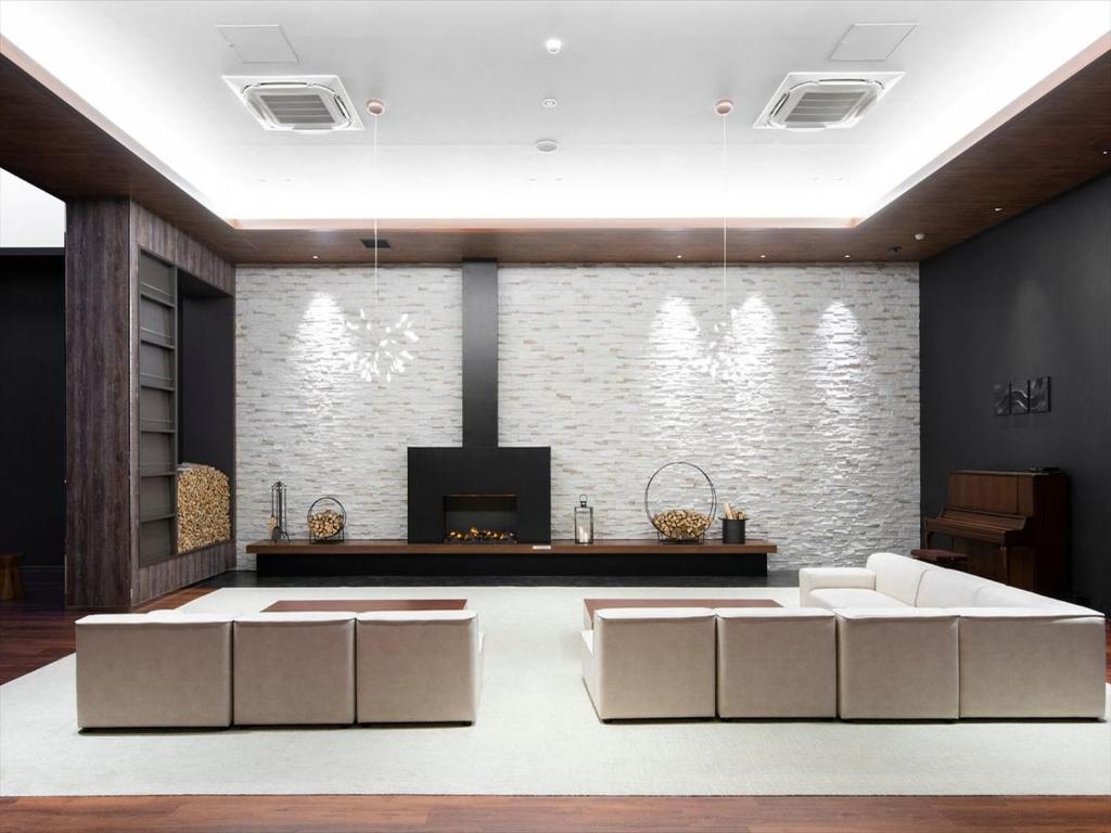 un salon avec deux canapés blancs et une cheminée dans l'établissement TORIFITO HOTEL&POD NISEKO, à Kutchan