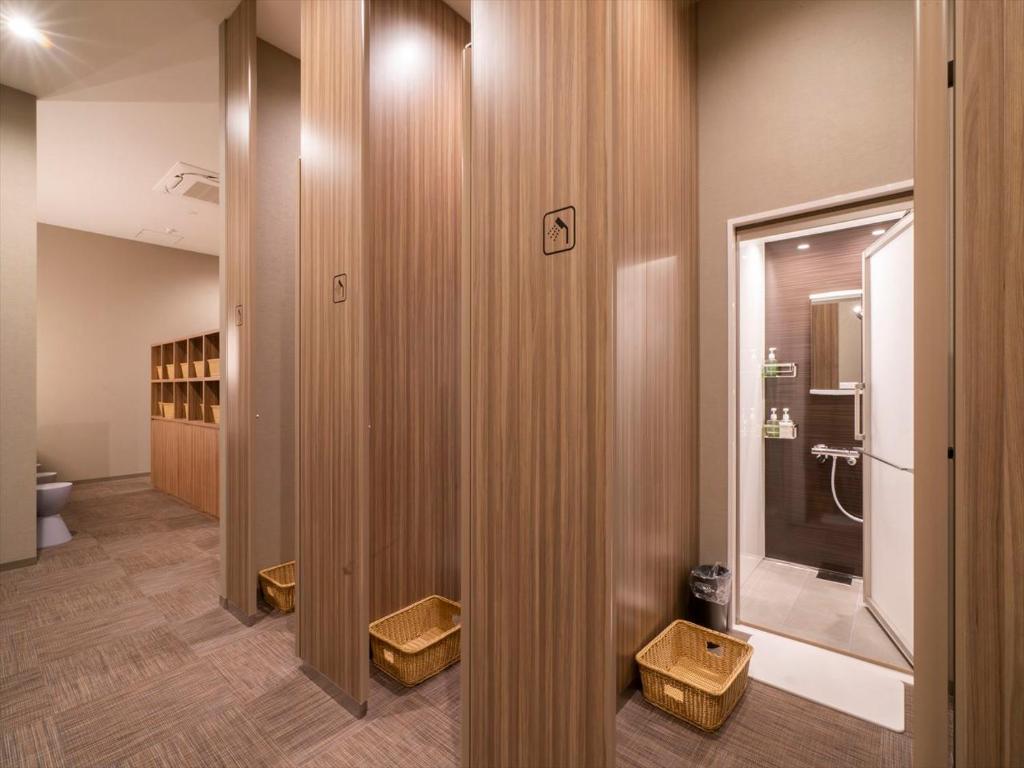 La salle de bains est pourvue de toilettes et de murs en bois. dans l'établissement TORIFITO HOTEL&POD NISEKO, à Kutchan