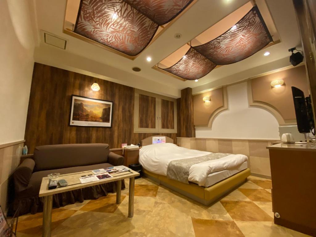 - une chambre avec un lit, un canapé et des lucarnes dans l'établissement Shonan Sirene (Adult Only), à Hiratsuka
