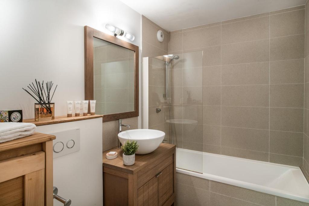 une salle de bain avec une baignoire, un lavabo et une douche dans l'établissement K2 by Alpine Resorts, aux Gets 37 autres photos