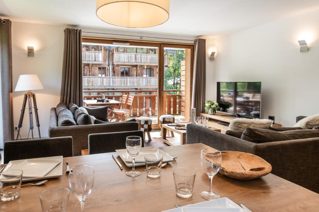 - un salon avec une table et des verres à vin dans l'établissement K2 by Alpine Resorts, aux Gets