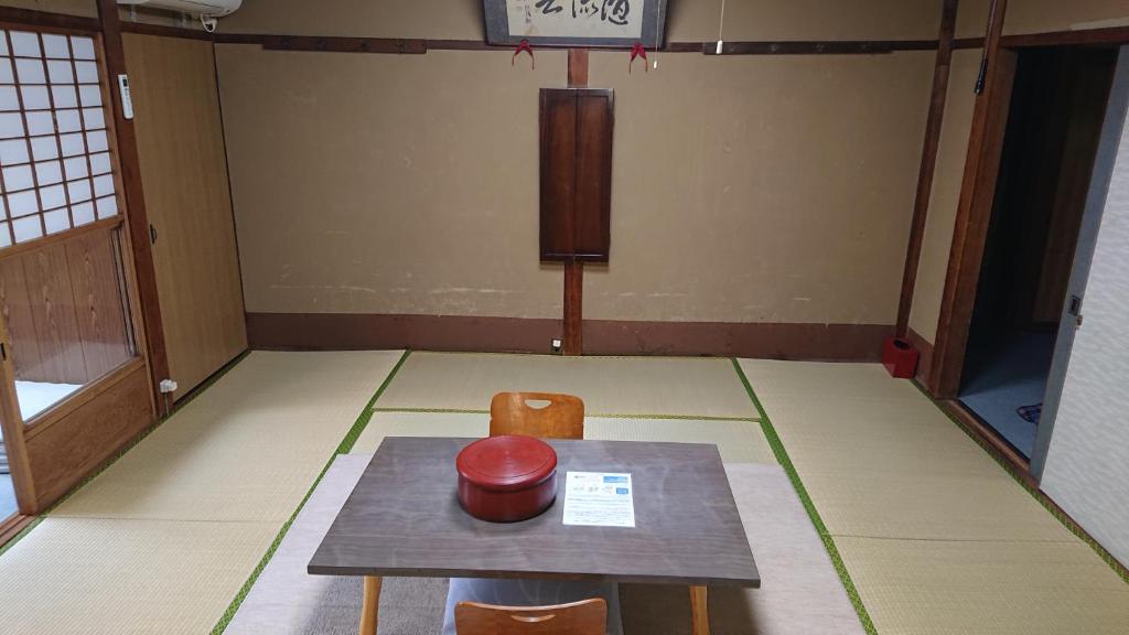 une chambre avec une table et deux chaises ainsi qu'un panier de basket-ball dans l'établissement Wajimaya Ryokan, à Kyoto