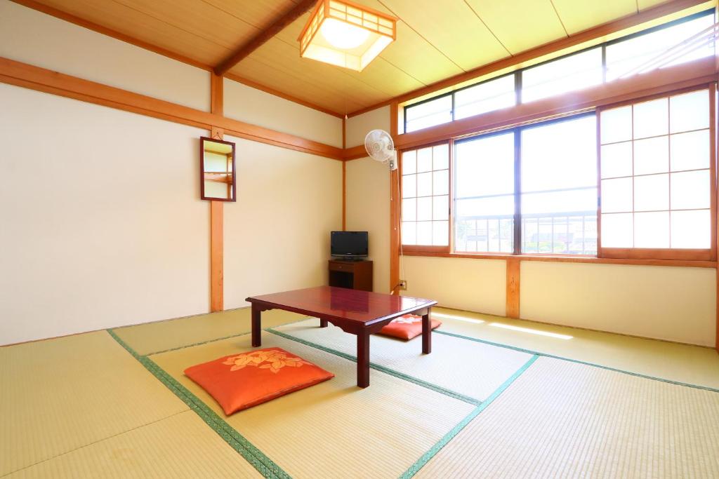 une pièce avec une table dans une pièce avec des fenêtres dans l'établissement Lake Oshino, à Oshino
