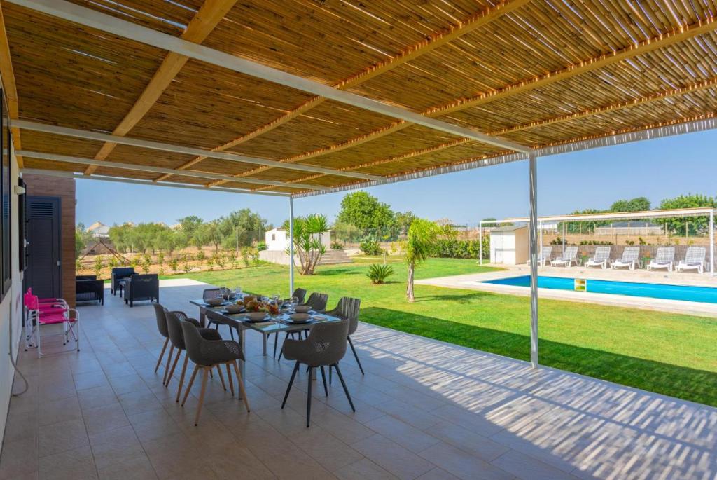 un patio avec une table et des chaises et une piscine dans l'établissement Villa Akos, à Raguse