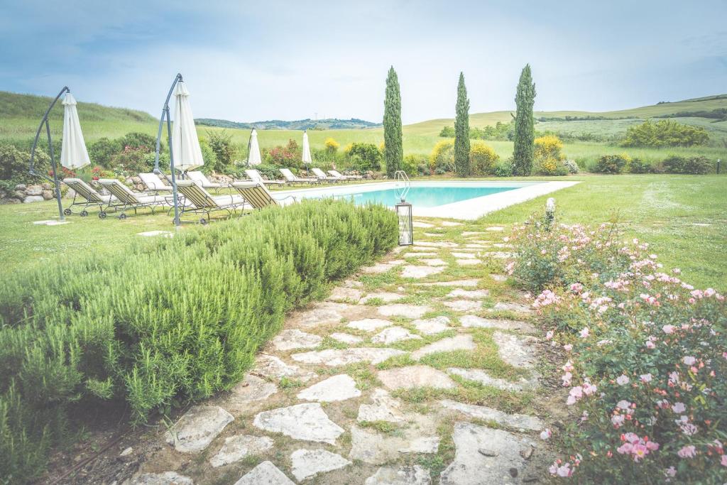 - une piscine dans une cour avec des chaises et des parasols dans l'établissement Villa d'Orcia - Homelike Villas, à Castiglione dʼOrcia