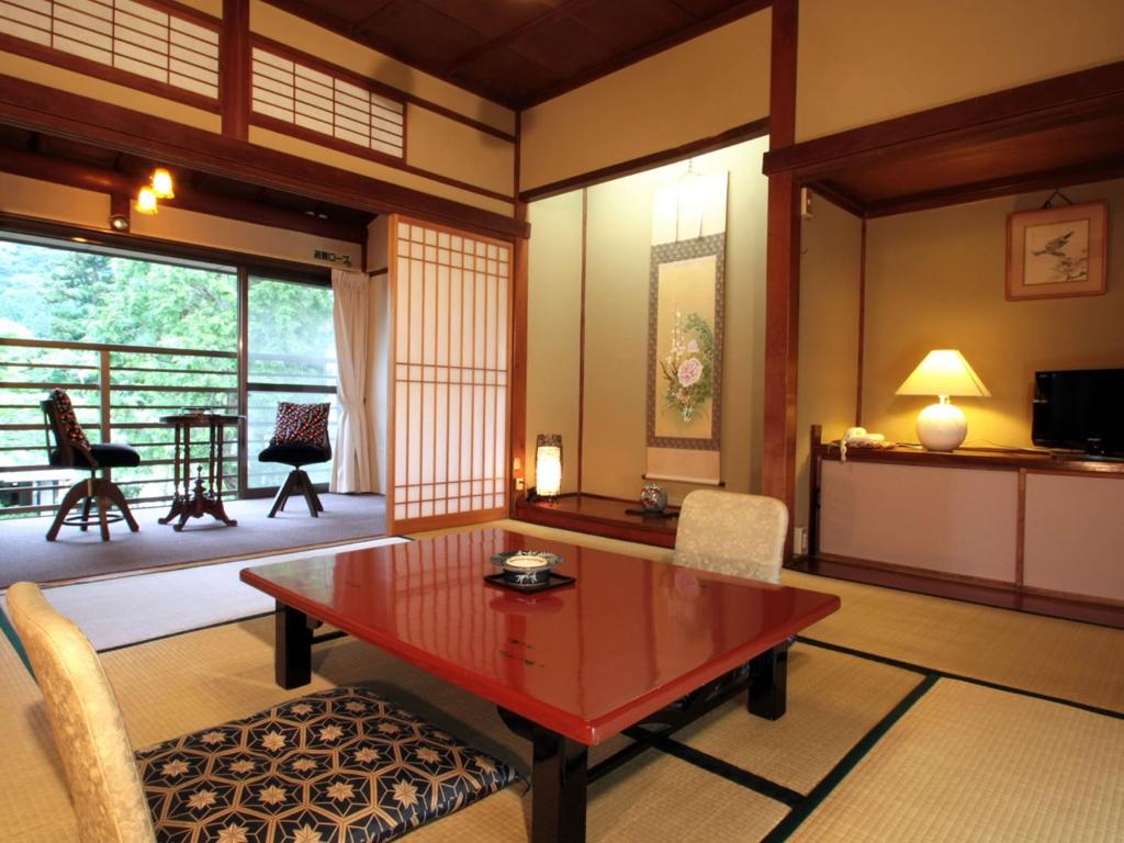 un salon avec une table et des chaises dans l'établissement Kinokuniya Ryokan, à Hakone