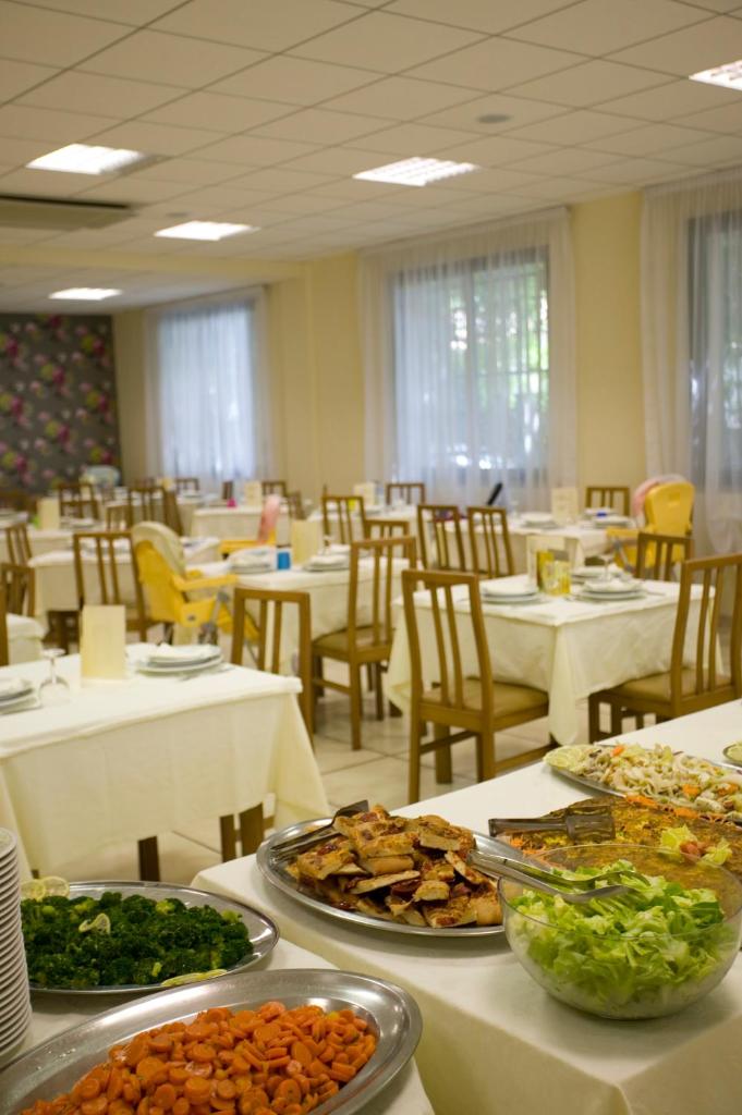 - une salle à manger avec des assiettes de nourriture sur les tables dans l'établissement Hotel Maré - Valentini Family Village, à Bellaria-Igea Marina