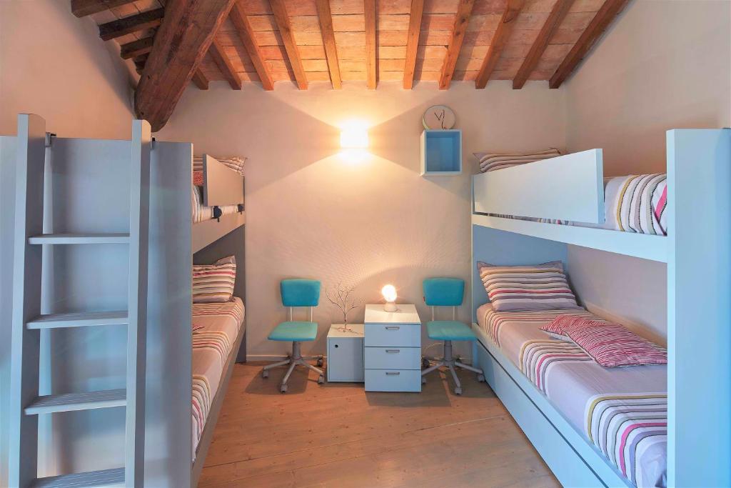 - une chambre avec 2 lits superposés et 2 chaises dans l'établissement Casa Ventinove, à Spolète