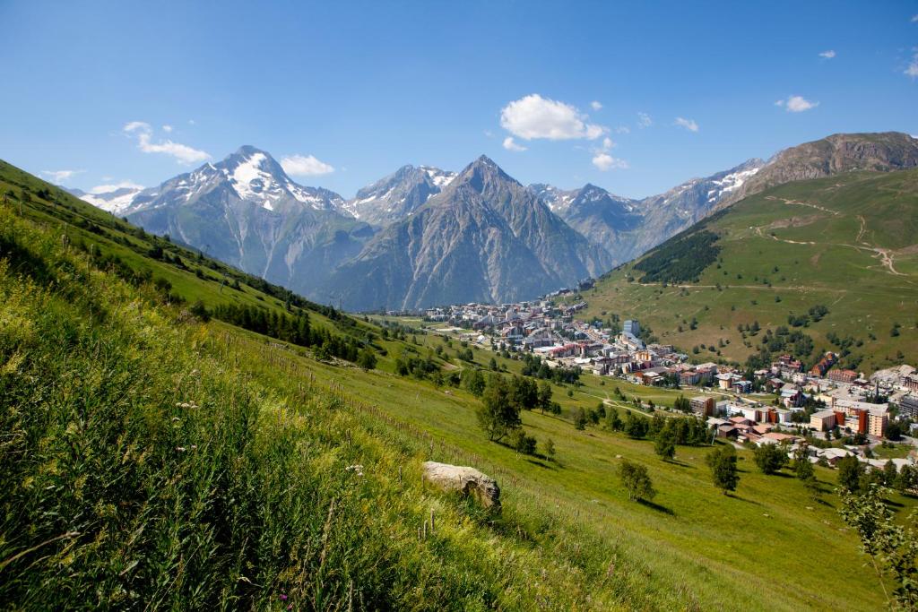 une ville sur une colline avec des montagnes en arrière-plan dans l'établissement Hotel Cote Brune, à Les Deux Alpes