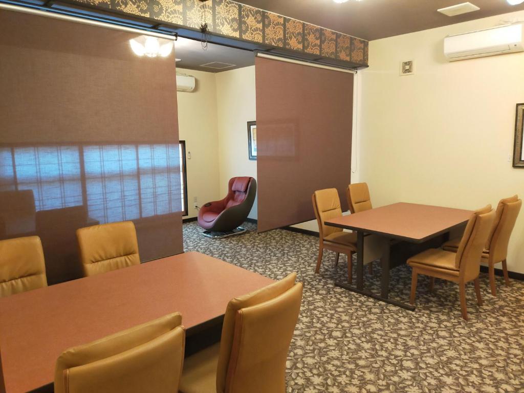 une salle de conférence avec deux tables et des chaises dans l'établissement Yurakuan Miyazaki, à Miyazaki