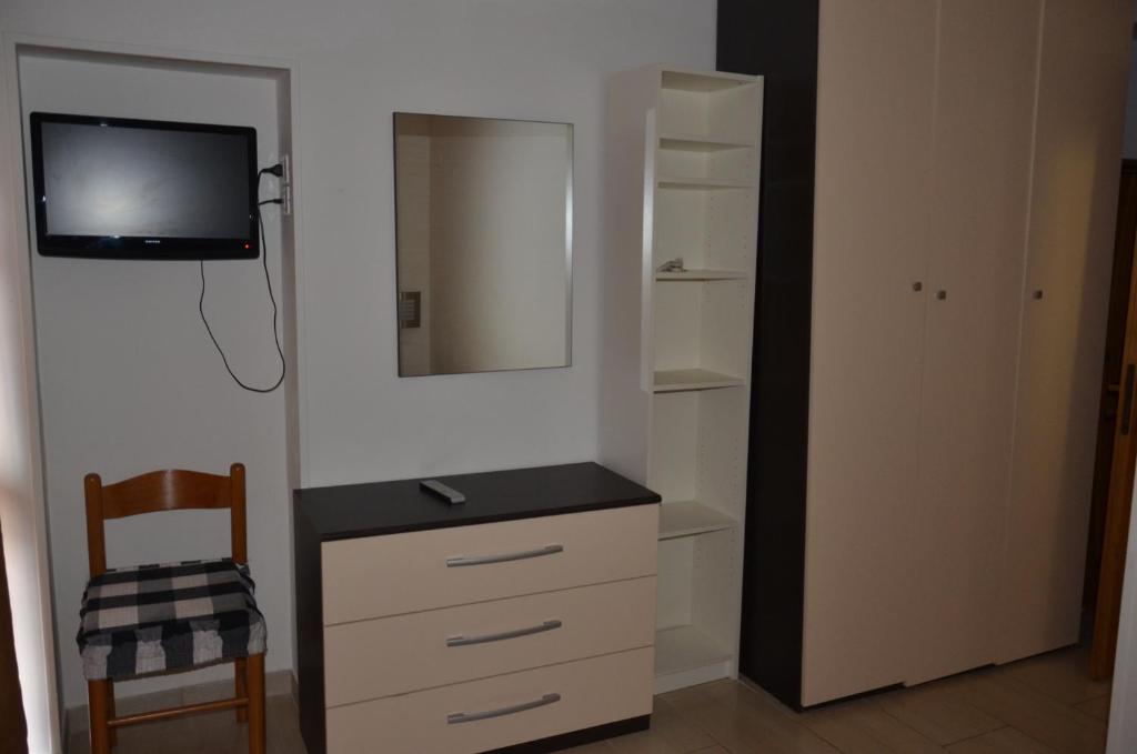 une chambre avec une commode avec un miroir et une télévision dans l'établissement Residence Della Vista, à Rimini