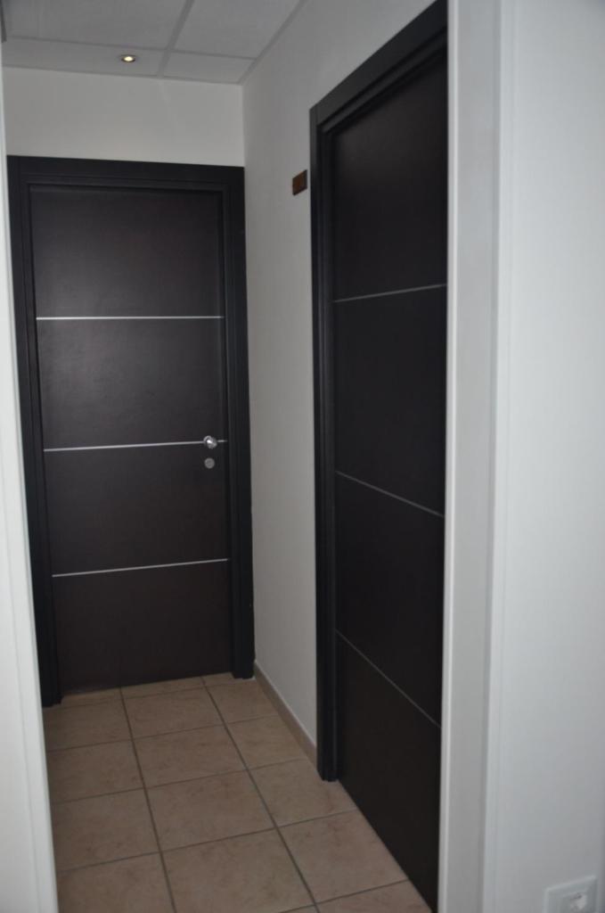 - deux portes noires dans un couloir avec du carrelage dans l'établissement Residence Della Vista, à Rimini