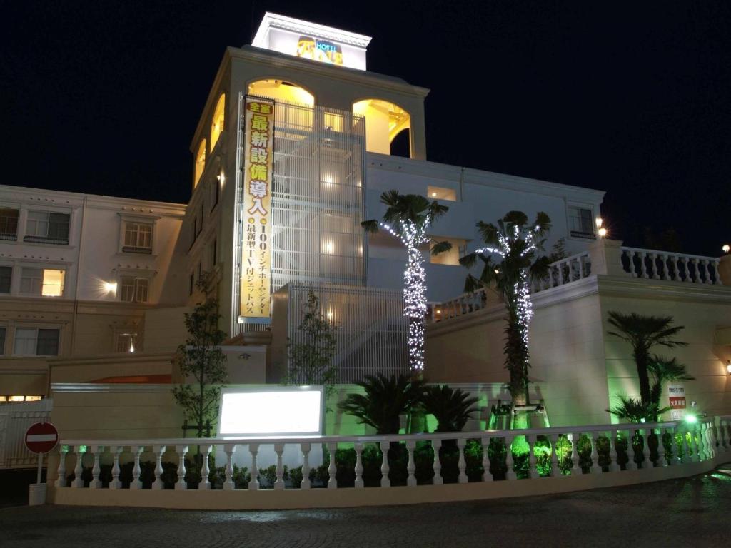 un bâtiment avec une tour éclairée la nuit dans l'établissement Hotel Fine Garden Toyonaka Osaka International Itami Airport, à Toyonaka