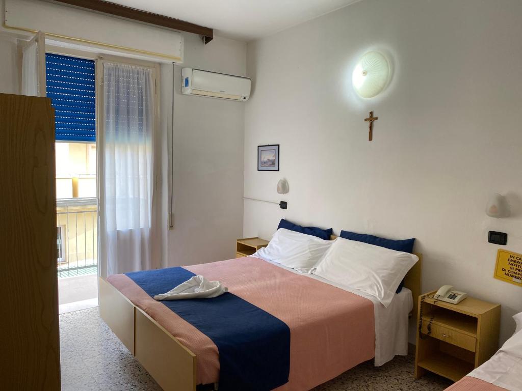- une chambre avec un lit et une croix sur le mur dans l'établissement Dea Della Salute Hotel, à Bellaria-Igea Marina 189 autres photos