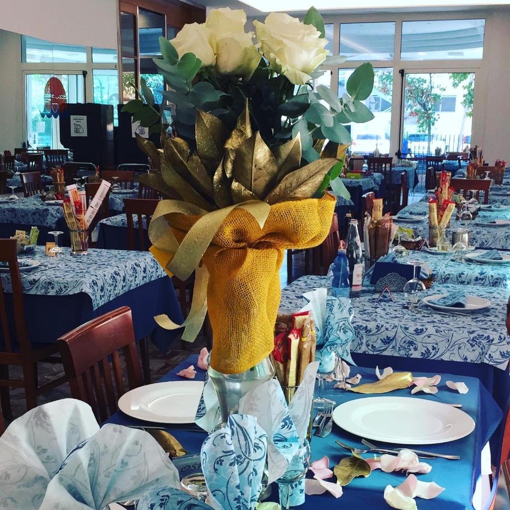 un vase rempli de fleurs sur une table dans l'établissement Dea Della Salute Hotel, à Bellaria-Igea Marina