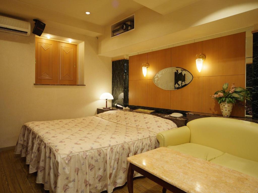 une chambre d'hôtel avec deux lits et un canapé dans l'établissement Hotel Fine Misaki, à Misaki