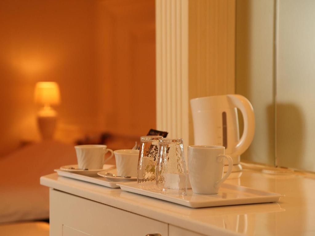 un plateau avec des tasses et des soucoupes sur une table dans l'établissement Hotel Fine Misaki, à Misaki