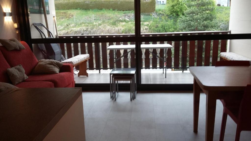 un salon avec une table et des chaises et un balcon dans l'établissement résidence Le Platé, aux Carroz d'Arâches 24 autres photos