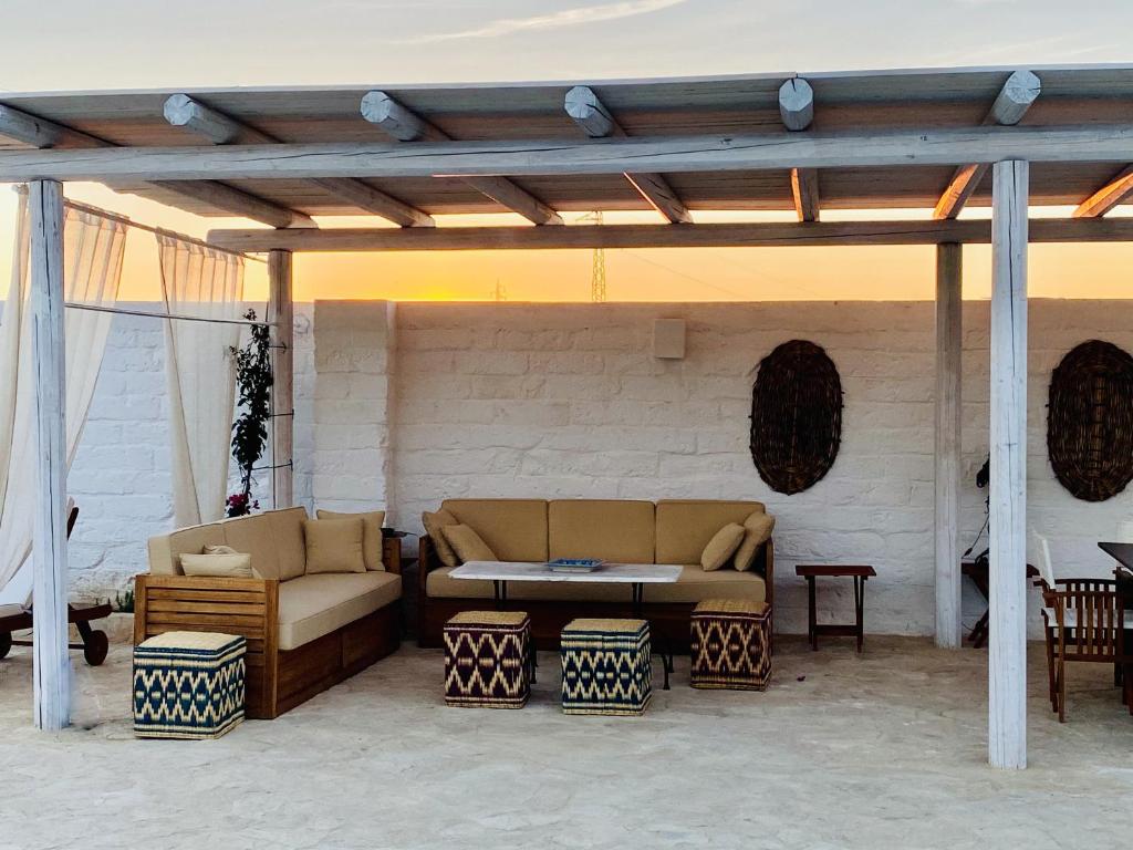 un patio avec un canapé, une table et des chaises dans l'établissement Masseria Villa Gioia, à Corato