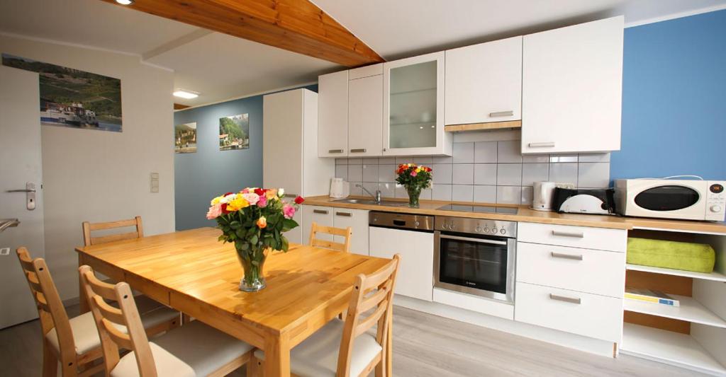une cuisine avec une table en bois et des fleurs. dans l'établissement Kuhnle-Tours Niderviller, à Niderviller