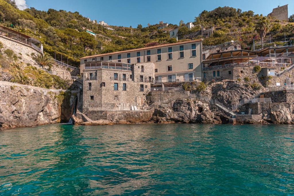 un bâtiment sur une falaise à côté de l'eau dans l'établissement Ravello Art Hotel Marmorata, à Ravello 71 autres photos
