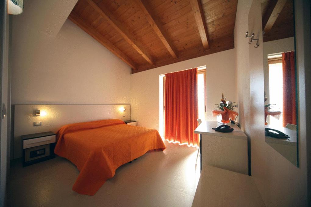 une chambre avec un lit orange et une fenêtre dans l'établissement Hotel Incontro, à Peschici 30 autres photos